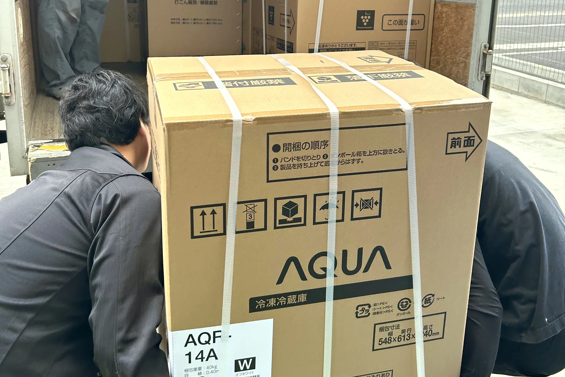 大型の洗濯機の箱をトラックへ積み込むところ