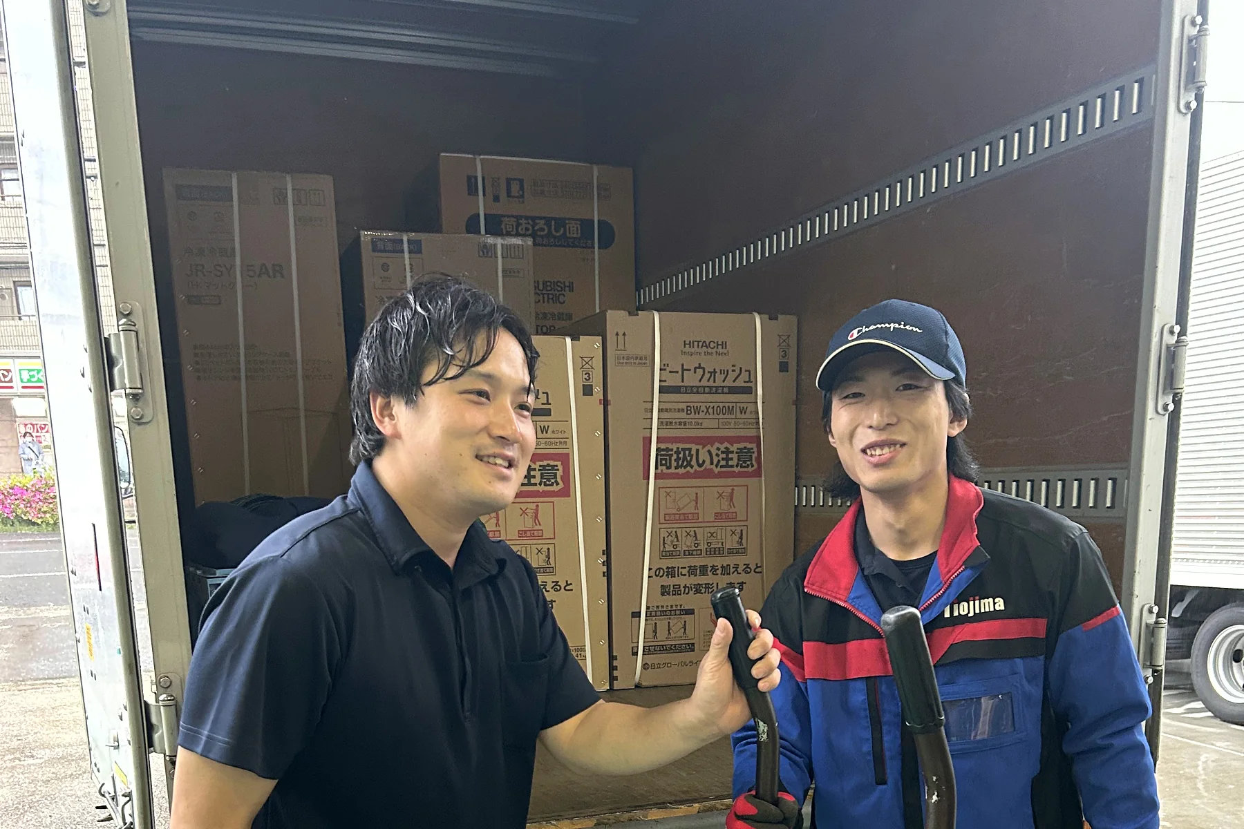 配送の合間に笑い合う現場の2人